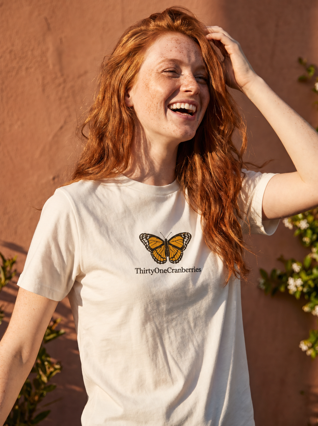 Redhead model in her thirties wearing the ThirtyOneCranberries Butterfly Tee with the butterfly and wordmark centered on the chest